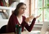 Woman frustrated with smartphone at desk