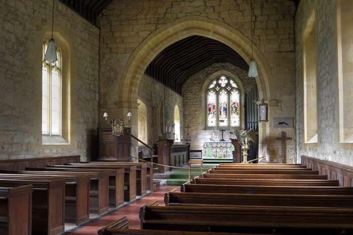 Church interior with wooden pews and stained glass altar